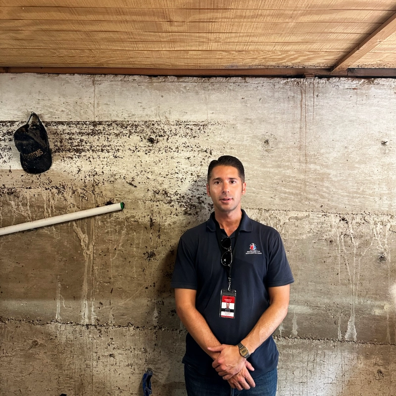 WAFRT team member standing in flood-marked room