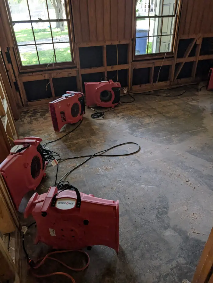 Industrial air movers drying a room with flood cuts after water damage in Hunt, Texas